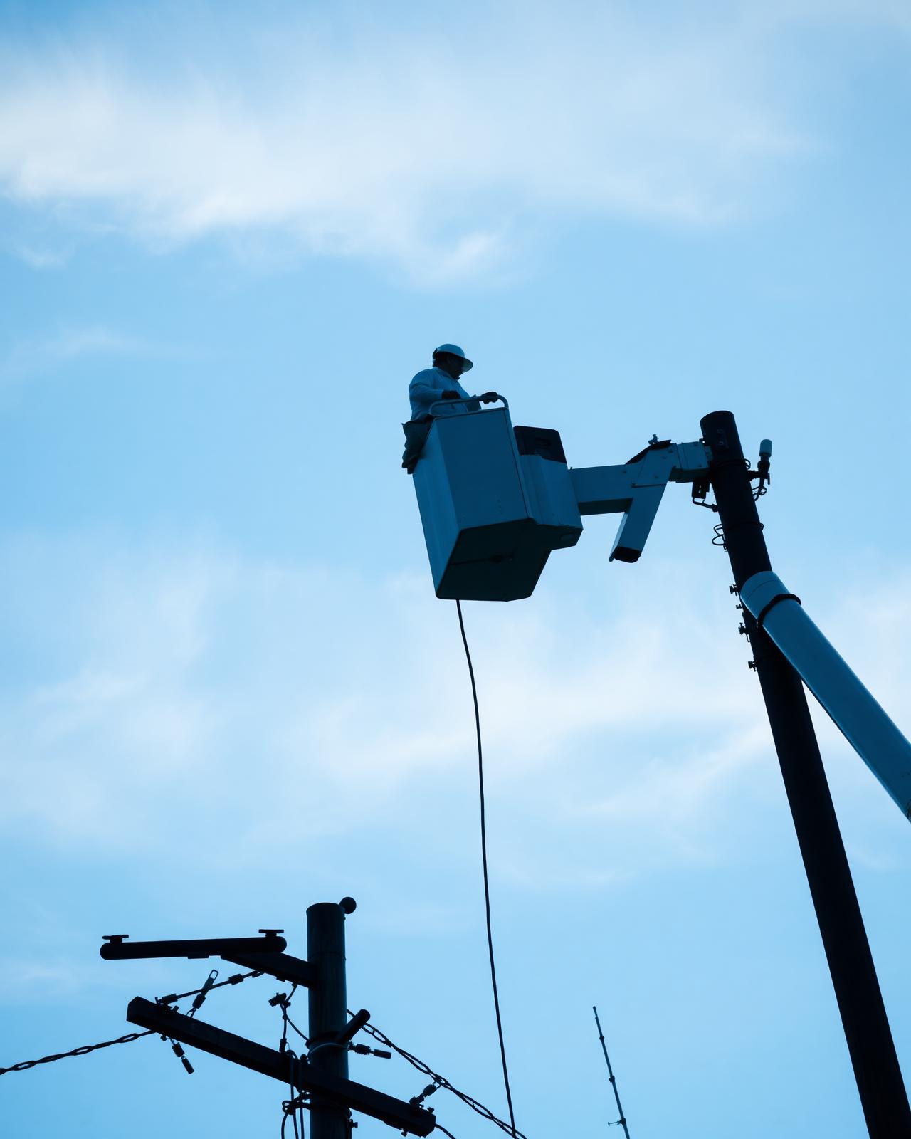 Lineman installing aerial fiber from a bucket truck